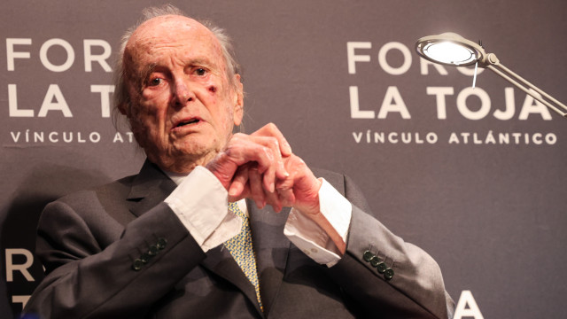 Francisco Pinto Balsemão, idoso, sentado num palco durante um evento formal, com fundo que indica 'Foro La Toja', em contexto de homenagem e reconhecimento público.