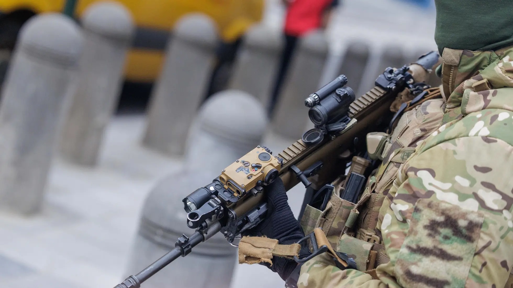 Militar com uniforme de camuflado e arma em patrulha numa rua de Bruxelas, ilustrando o reforço de segurança devido à violência e ao narcotráfico.