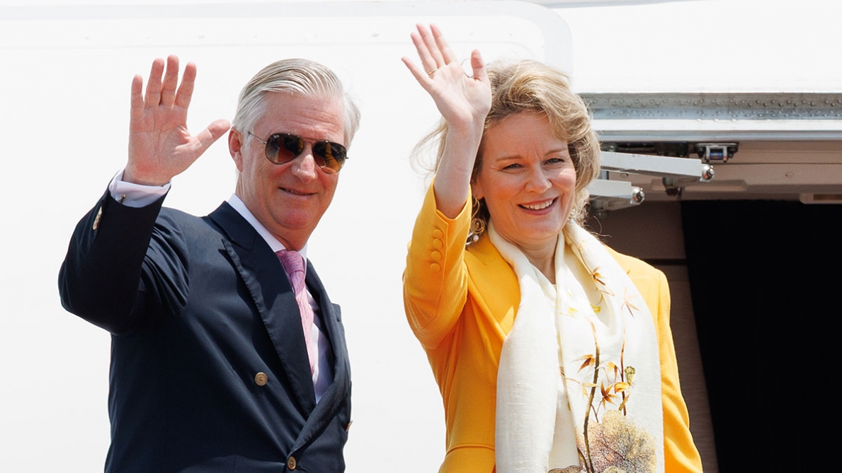Os reis da Bélgica, Filipe e Matilde, acenam juntos ao lado de um avião, num momento público relacionado com as cerimónias de homenagem às vítimas dos atentados de Bruxelas.