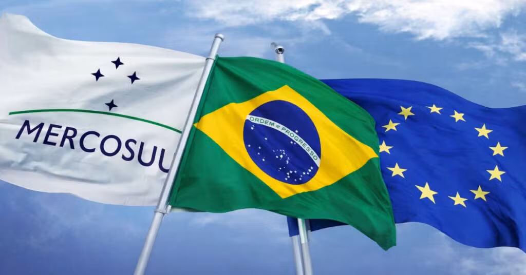 Vista panorâmica de uma grande cidade com muitos edifícios e casas, sob um céu parcialmente nublado, sugerindo desenvolvimento urbano e integração económica.
